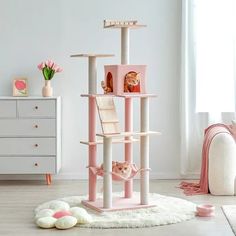 a pink cat tree in the corner of a room with flowers and stuffed animals on it