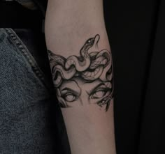 a woman with a snake tattoo on her arm