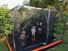 three children are playing in an outdoor trampoline