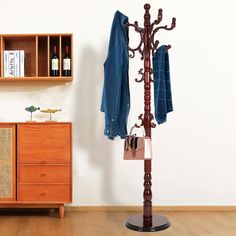 a coat rack with two coats hanging from it's sides next to a dresser