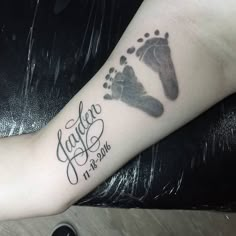 a person with a tattoo on their arm that has a baby's foot and name