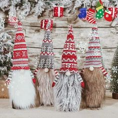 three gnomes are standing next to each other in front of christmas decorations and trees