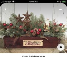 a wooden box filled with pine cones and christmas decorations