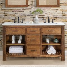 a bathroom vanity with two mirrors above it and towels on the bottom shelf next to it