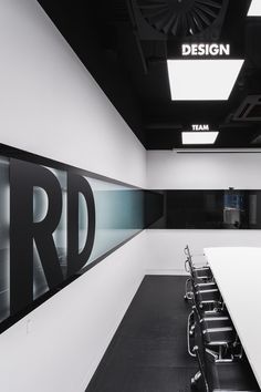 an empty conference room with long tables and chairs in front of the wall that says design