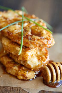 some food is stacked on top of each other with a honey comb next to it