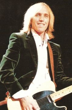 a man with long hair playing an electric guitar