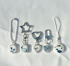 four different shaped keychains on a white sheet with a star, heart, and other items