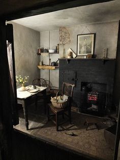 a room with a fireplace, table and chairs