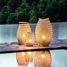 three vases sitting on top of a table next to a pool