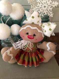 a teddy bear dressed in a dress next to snowflakes and other holiday decorations