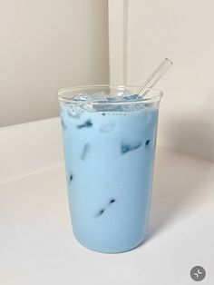 a blue drink with ice and straw in it