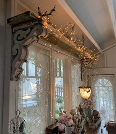 a room filled with lots of windows covered in string lights and flowers on the window sill