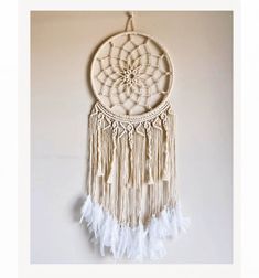 a white dream catcher hanging on the wall