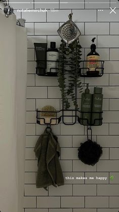 a bathroom with white tile and black metal shelving on the wall next to a shower