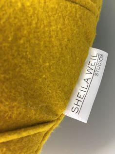 the label is attached to a yellow wool material that looks like it has been dyed