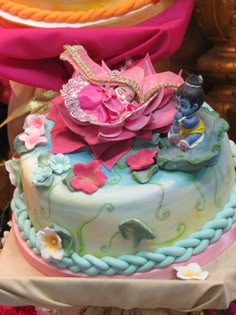 there is a cake decorated with flowers and figurines on the top of it