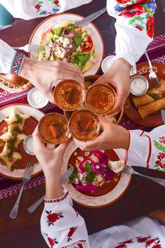 people toasting with glasses at a festive table full of food and drinks royalty images