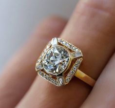 a close up of a person's hand with a diamond ring on their finger