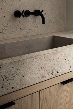 a kitchen sink sitting under a faucet next to a counter top with drawers