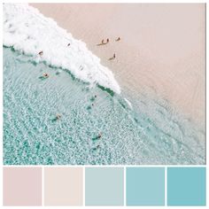 people are swimming in the ocean with their surfboards and paddles on the beach