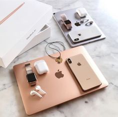 two apple products are sitting on a marble counter top, one is gold and the other is silver