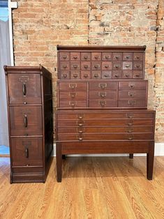 two wooden dressers sitting next to each other in front of a brick wall