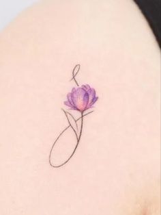 a small purple flower on the back of a woman's shoulder, with an arrow in it