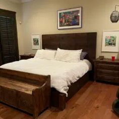 a bed sitting in a bedroom on top of a hard wood floor next to a dresser