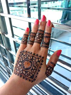 a woman's hand with henna tattoos on it