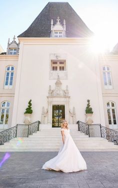 a woman standing in front of a large white building