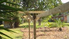 a wooden pole in the middle of a yard with palm trees and bushes around it