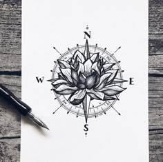 a black and white drawing of a lotus flower on paper with compass symbol in the background