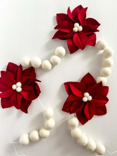 poinsettis and beads are arranged on a white surface