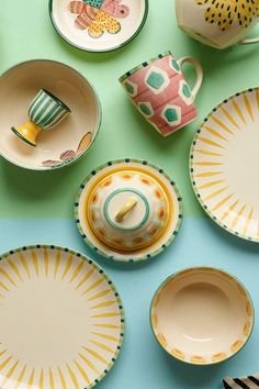 colorful dishes and cups are arranged on a table