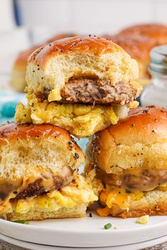 three hamburger sliders stacked on top of each other with cheese and meat in the middle