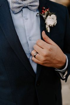 a close up of a person wearing a suit and bow tie