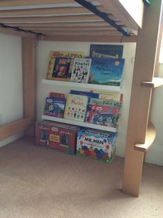 the bookshelf is full of children's books and has two shelves for them