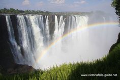 a large waterfall with a rainbow in the middle and water cascading over it