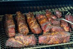 steaks and ribs are cooking on the grill