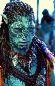 a close up of a person with dreadlocks and blue paint on their face