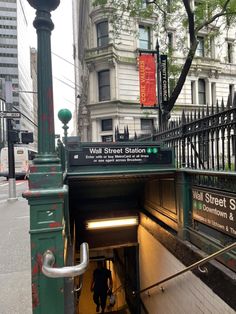 a man is walking out of a tunnel on the sidewalk in front of a building