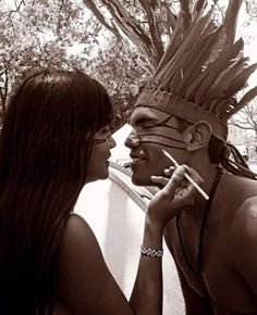 a man and woman that are standing next to each other in front of a tree