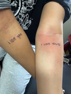 two people with arm tattoos that say i love you