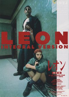 two people are sitting on the floor in front of a wall with red lettering that says leon