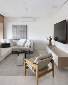 a modern living room with white furniture and wood accents