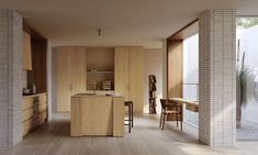 an open kitchen and dining area with wood flooring, white brick walls and cabinets