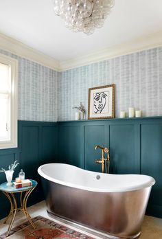 a bathroom with green walls and a white bathtub in the middle of the room