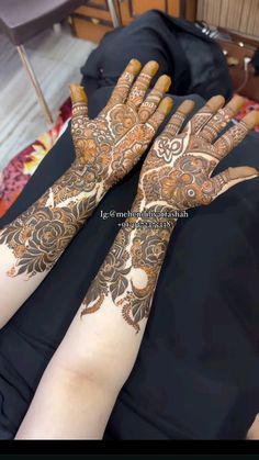 two hands with henna tattoos on them