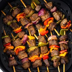 the skewers are being cooked on the grill with peppers, onions and meat